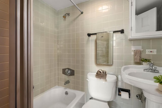 full bathroom featuring tile walls, tiled shower / bath combo, decorative backsplash, and toilet