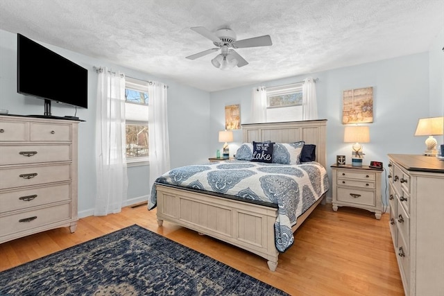 bedroom with visible vents, ceiling fan, light wood-style flooring, and a textured ceiling