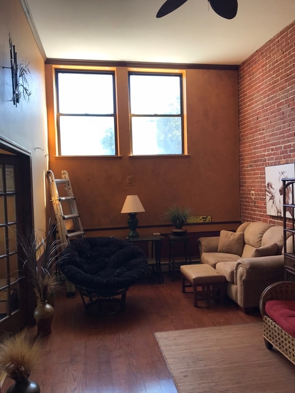 living room featuring ceiling fan, ornamental molding, and hardwood / wood-style flooring