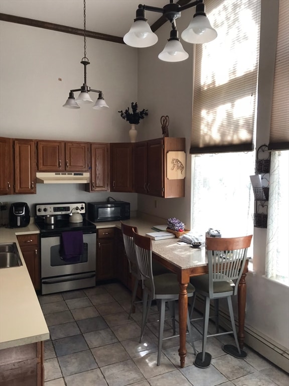 kitchen with decorative light fixtures, a wealth of natural light, stainless steel range with electric cooktop, and light tile patterned flooring