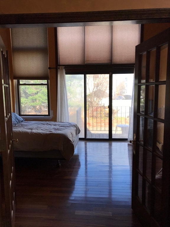 bedroom featuring access to outside and dark wood-type flooring