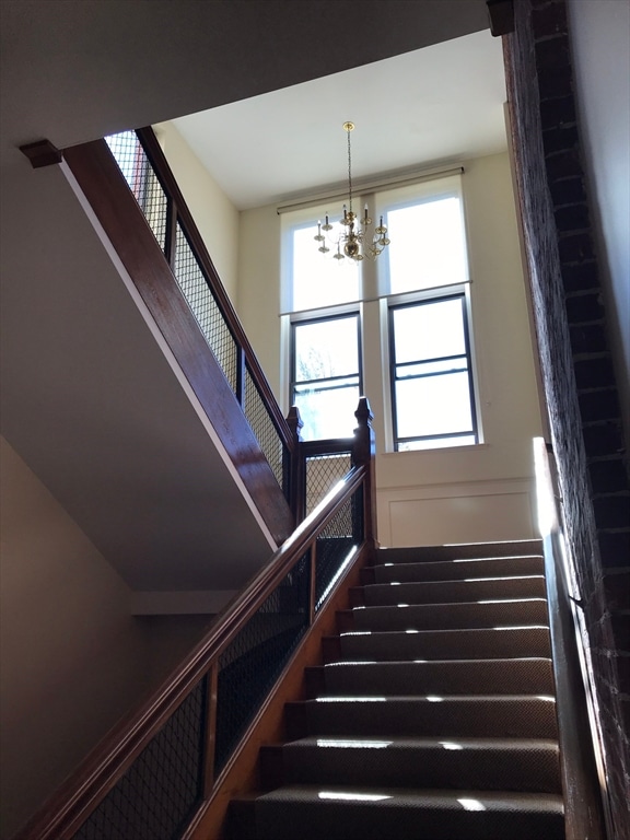 staircase with a chandelier