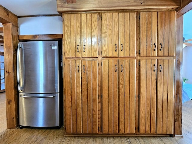 kitchen with stainless steel refrigerator and light hardwood / wood-style flooring