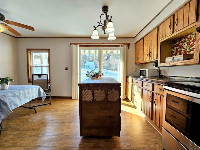 kitchen with a kitchen island, decorative light fixtures, stainless steel range with electric cooktop, ornamental molding, and light wood-type flooring