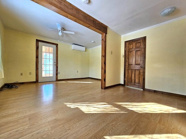 spare room featuring ornamental molding, a wall unit AC, ceiling fan, and light wood-type flooring