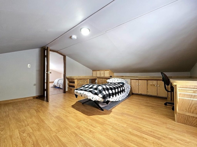 bedroom with lofted ceiling and light hardwood / wood-style flooring