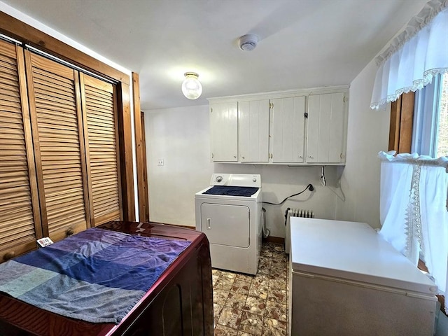 clothes washing area featuring cabinets and washing machine and clothes dryer