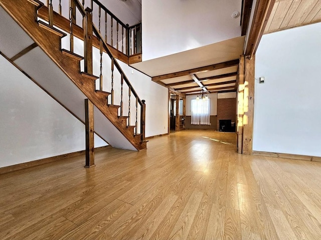 interior space with beamed ceiling, an inviting chandelier, and light hardwood / wood-style flooring