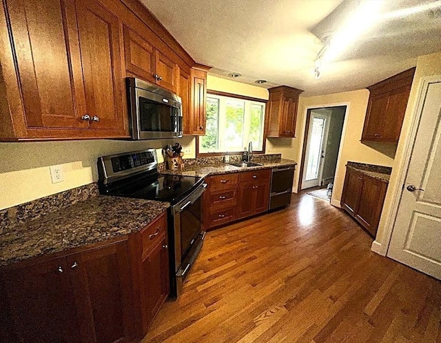 330 Chapin St, Ludlow, MA 01056 - kitchen featuring stainless steel appliances, dark wood-style flooring, a sink, dark stone countertops, and a textured ceiling