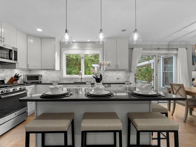 29 Shermans Way, Westwood, MA 02090 - kitchen with stainless steel appliances, dark countertops, a kitchen breakfast bar, tasteful backsplash, and recessed lighting