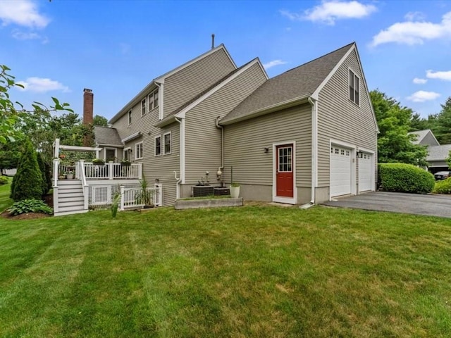 29 Shermans Way, Westwood, MA 02090 - rear view of house with asphalt driveway, a wooden deck, a lawn, and an attached garage