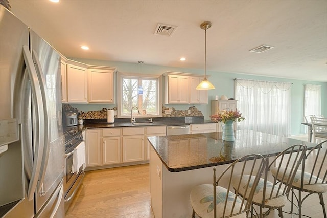 kitchen featuring a sink, a wealth of natural light, stainless steel appliances, and visible vents