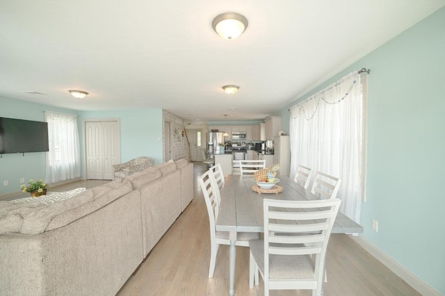 dining room with baseboards and light wood finished floors