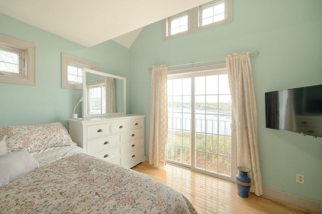 bedroom featuring light wood-style floors, high vaulted ceiling, baseboards, and access to exterior