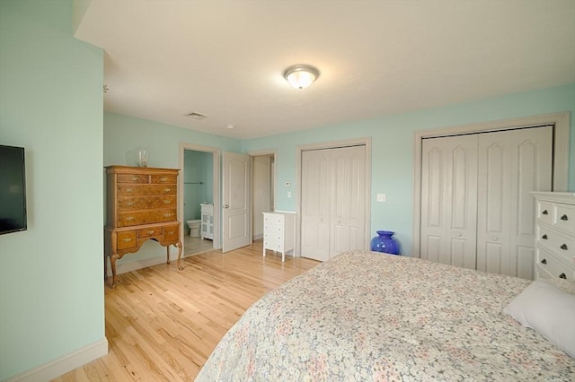 bedroom with light wood-style floors, multiple closets, baseboards, and visible vents