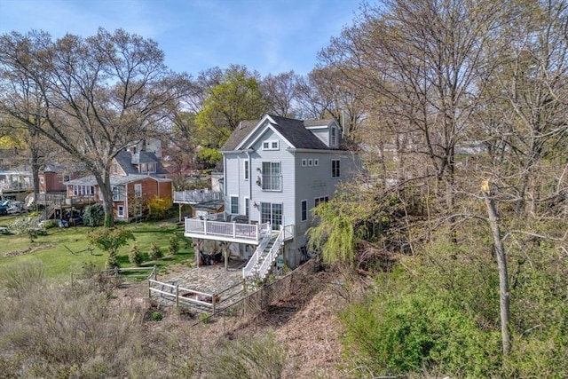 rear view of property featuring stairs, fence private yard, and a deck