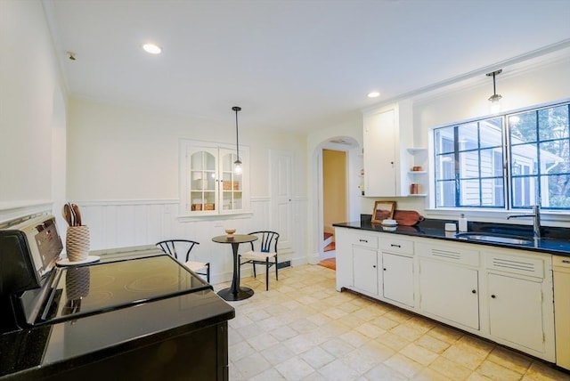 kitchen with white cabinetry, sink, decorative light fixtures, and stainless steel electric range