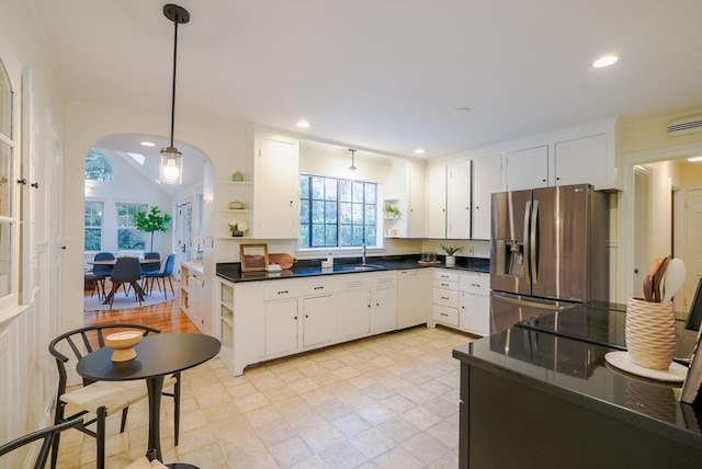 kitchen featuring white cabinetry, stainless steel fridge, sink, and pendant lighting