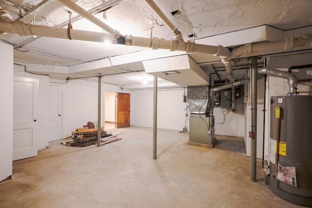 basement featuring electric panel, heating unit, and gas water heater