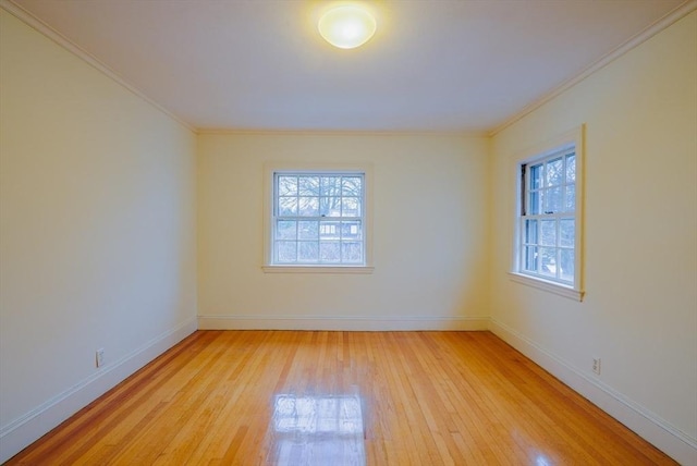 empty room featuring crown molding and light wood-type flooring