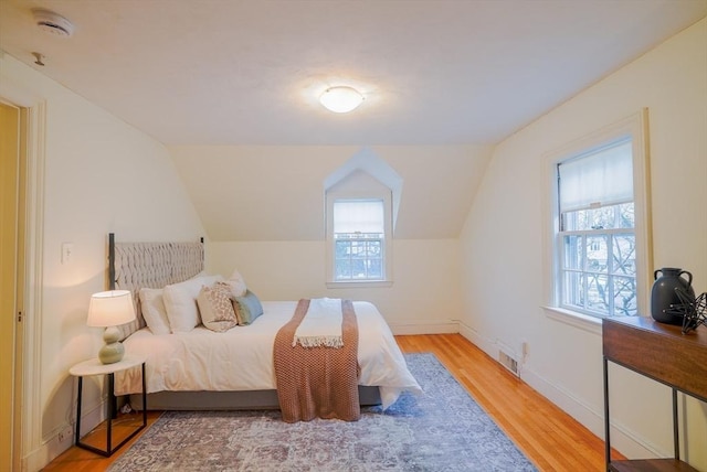 bedroom featuring vaulted ceiling and light hardwood / wood-style floors