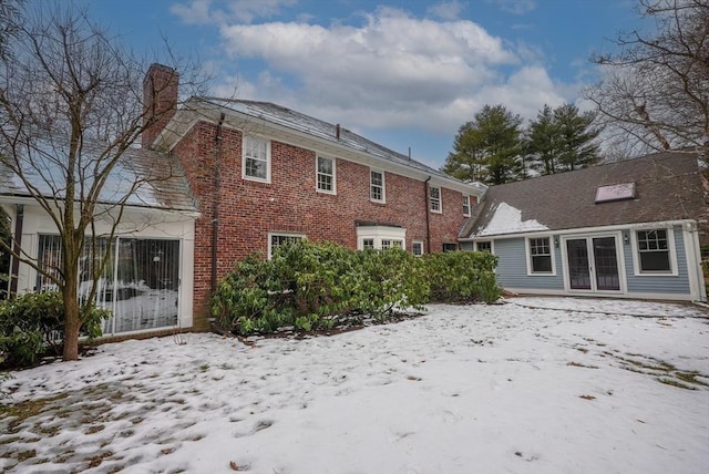 view of snow covered back of property