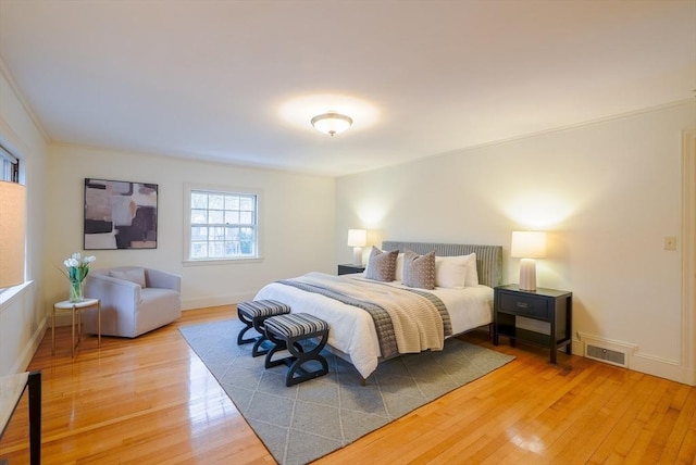 bedroom with wood-type flooring and crown molding