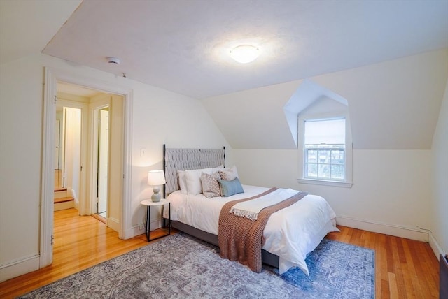 bedroom featuring hardwood / wood-style flooring and vaulted ceiling