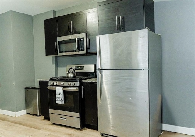 58-60 Virginia St, Springfield, MA 01108 - kitchen with appliances with stainless steel finishes, dark cabinetry, baseboards, and light wood-style flooring