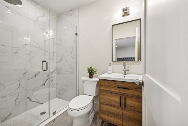 bathroom with a shower with door, vanity, and toilet