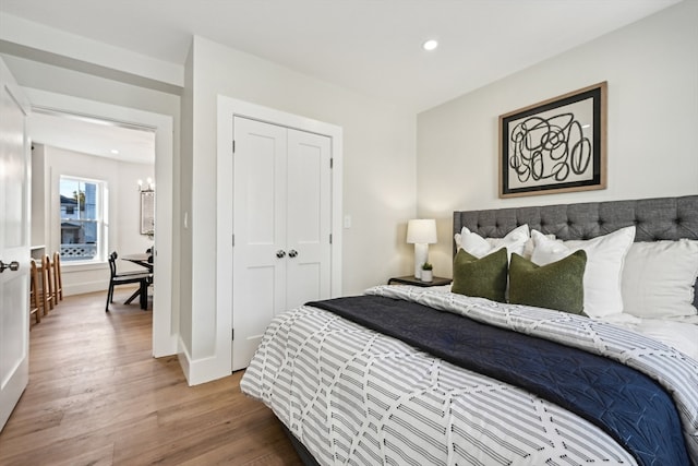 bedroom featuring hardwood / wood-style flooring, a chandelier, and a closet