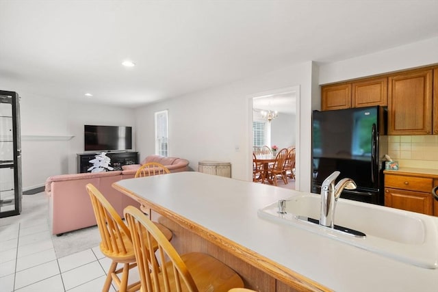 79 Brookdale Cir Unit 79, Shrewsbury, MA 01545 - kitchen with freestanding refrigerator, light tile patterned flooring, a breakfast bar area, brown cabinets, and recessed lighting