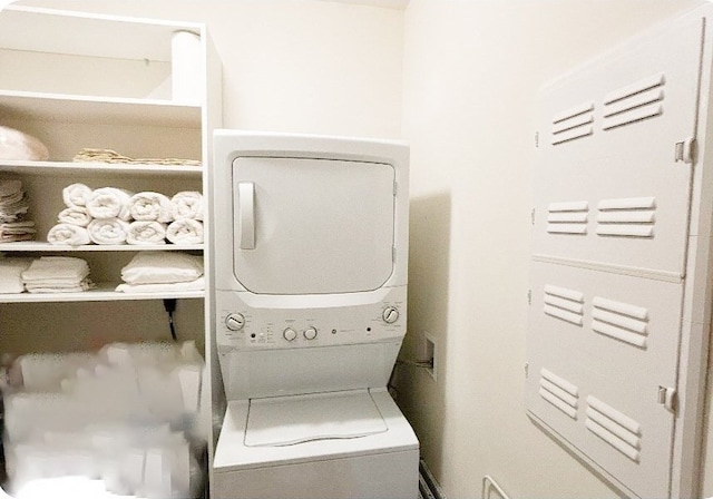 laundry room featuring stacked washer / drying machine