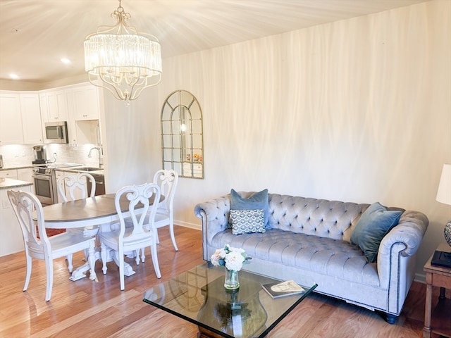 living room featuring a chandelier, sink, and hardwood / wood-style flooring