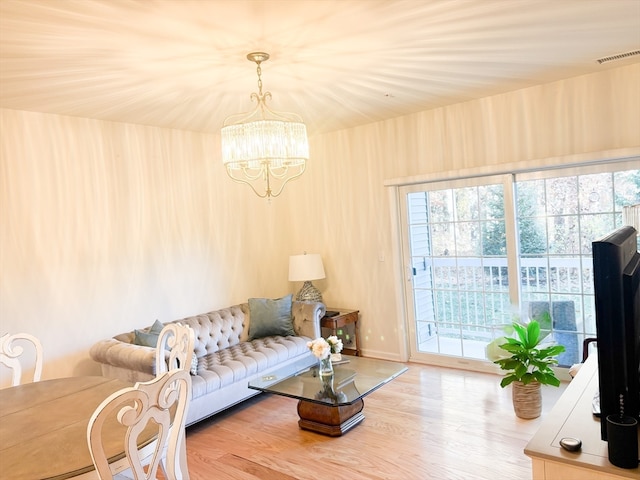 living room with hardwood / wood-style floors and a notable chandelier