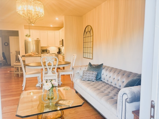 living room featuring an inviting chandelier and light wood-type flooring