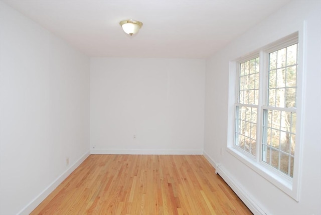 spare room featuring baseboards, light wood-style floors, and a healthy amount of sunlight