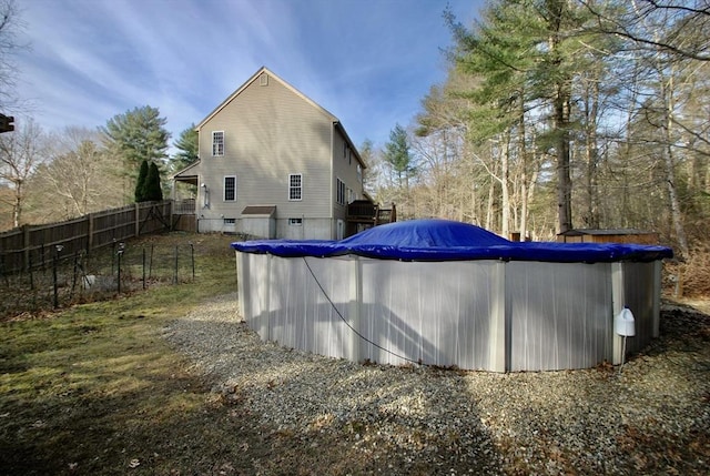 rear view of house featuring a fenced in pool and fence