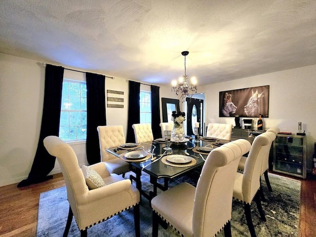 dining room featuring an inviting chandelier, hardwood / wood-style floors, and a textured ceiling