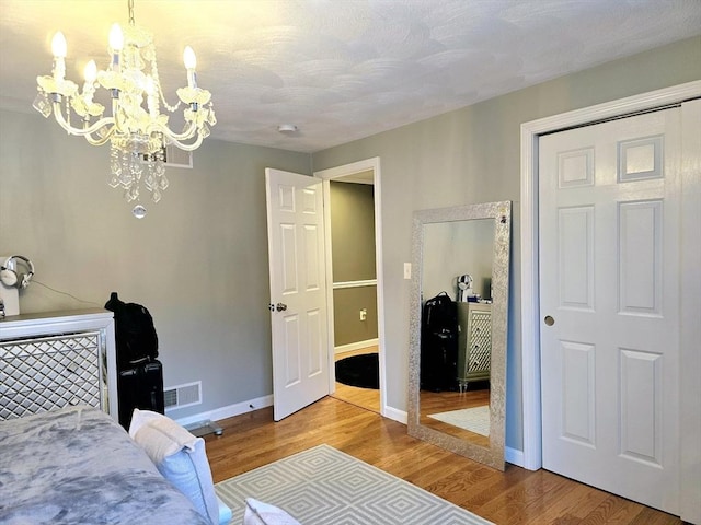 bedroom with a chandelier and hardwood / wood-style floors