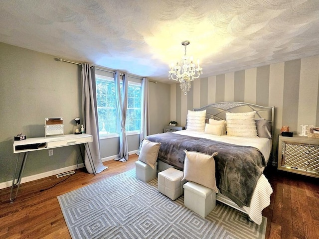 bedroom featuring an inviting chandelier, wood-type flooring, and a textured ceiling