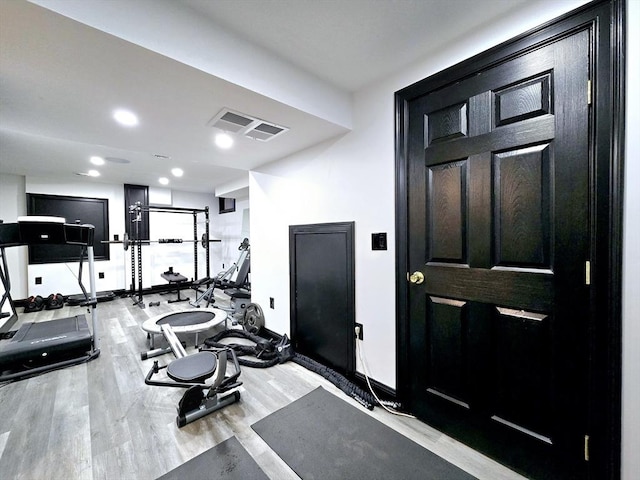 workout area with light hardwood / wood-style flooring