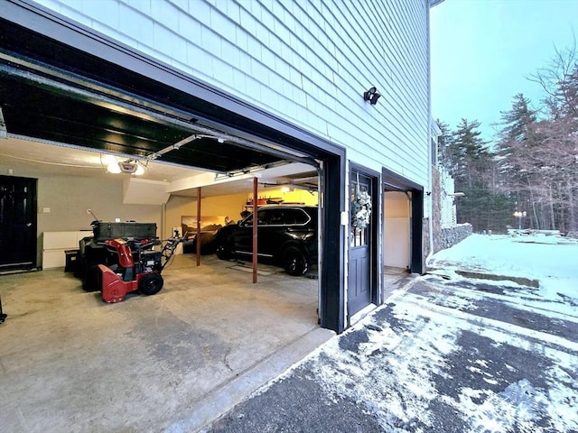 snow covered garage with a garage door opener