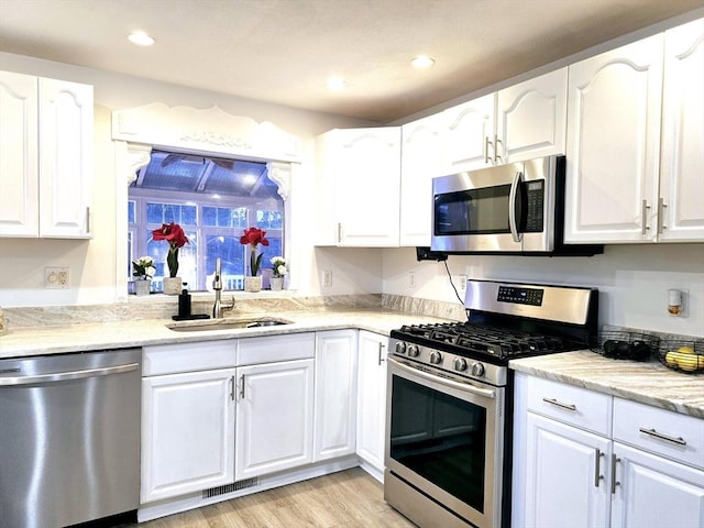 kitchen featuring white cabinetry, stainless steel appliances, and sink