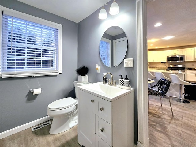 bathroom featuring vanity, hardwood / wood-style floors, and toilet