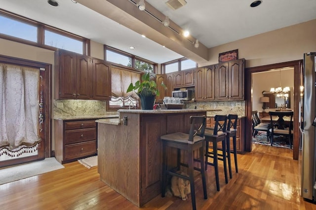97 Livingston Ave, Lowell, MA 01851 - kitchen featuring tasteful backsplash, a kitchen breakfast bar, light wood-style flooring, a kitchen island, and stainless steel appliances
