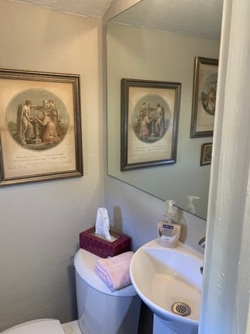 bathroom featuring sink, a textured ceiling, and toilet