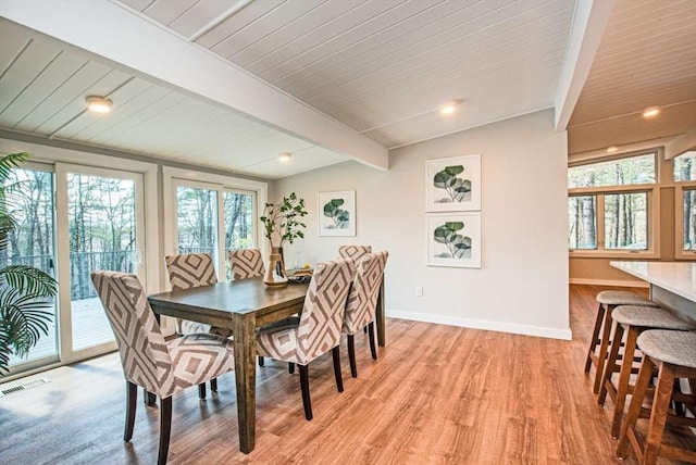 dining space with vaulted ceiling with beams, visible vents, light wood-type flooring, wooden ceiling, and baseboards