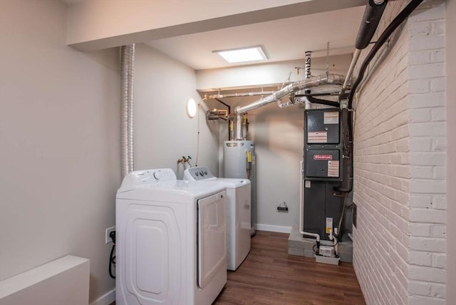 laundry room featuring heating unit, brick wall, wood finished floors, laundry area, and independent washer and dryer