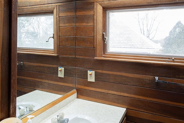 bathroom featuring wood walls and vanity